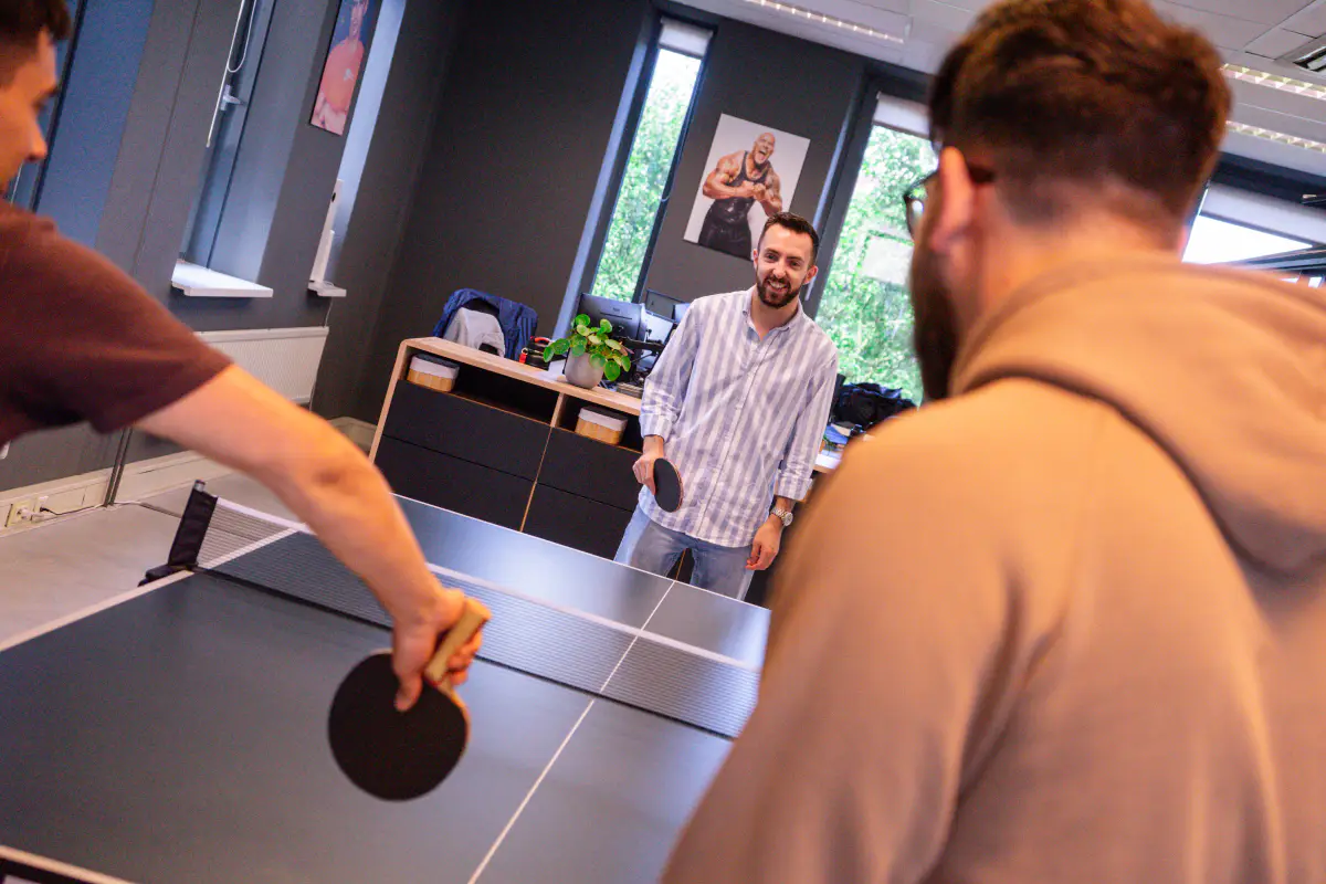 Drie personen die met elkaar ping-pongen